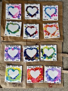 paper hearts are arranged on the ground for valentine's day crafting with colored watercolors