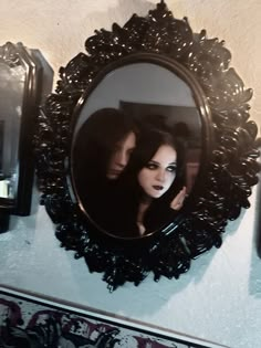 two women are reflected in a mirror on the wall