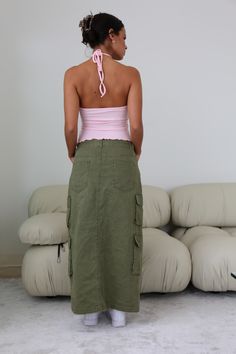 Step up your wardrobe game with the Olivia Cargo Maxi Skirt. Featuring Fall's staple color olive, this cargo maxi is designed to bring utility chic to life. Whether you keep it casual or dress it up, this is the piece you need to get you through the season in style! Make it your go-to and become everyone's style envy! Rigid with Minimal Stretch Center Front Slit Double Cargo Pockets 5 Pocket Maxi Silhouette 100% Cotton Model is 5'6 and wearing a size SMALL Green Cargo Maxi Skirt, Going Out Looks, Green Cargo, Corsets And Bustiers, Top Streetwear, Denim Details, Dress Romper, Step Up, Trend Setter