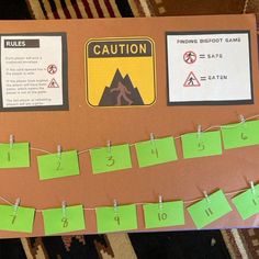 a bulletin board with green sticky notes attached to it's sides and two warning signs on each side