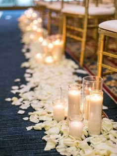 the aisle is lined with candles and petals