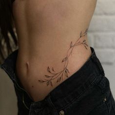 a woman's stomach with a tattoo on her lower back and the bottom part of her body