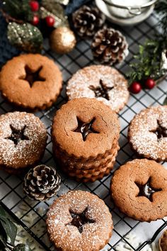 some cookies are sitting on a cooling rack with pine cones and christmas decorations around them