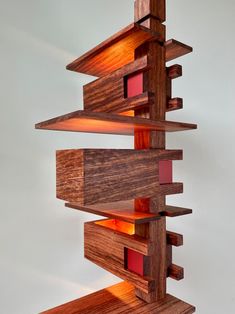 a sculpture made out of wood with red and yellow light coming from it's sides