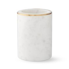 a white vase with gold trim on the top and bottom, sitting in front of a white background