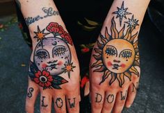 two hands with sun and moon tattoos on them, one has the word slow down painted on it