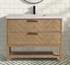 a bathroom vanity with white marble top and wooden drawers in front of a tiled wall