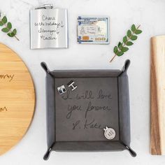 a tray with some writing on it next to a cutting board and two flasks