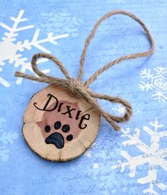 a wooden ornament with a dog's name and paw print on it