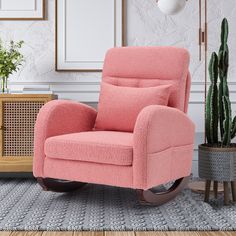 a living room with a pink chair and potted cactus