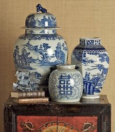 three blue and white vases sitting on top of a table