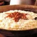 a wooden bowl filled with rice on top of a table