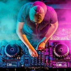 a dj mixing music in front of colorful lights