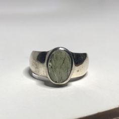 This genuine moldavite ring weighs 6.7 grams and measures to a US size 8 1/4. This rare stone sits in all sterling silver and a raw cut. Our Moldavite is guaranteed 100% genuine from the Czech Republic. Moldavite comes from a meteor collision with Earth almost 15 million years ago. Found only in the Czech Republic these green Gems are one of the most rare minerals on Earth. This tektite is composed of natural glass and is created when a meteorite collides with earth resulting in this green speci Modern Oval Gemstones As Gift, Modern Oval Silver Gemstones, Modernist Oval Jewelry For Formal Occasions, Handmade Oval Emerald Ring, Modernist Hallmarked Oval Jewelry, Modern Oval Sterling Silver Gemstones, Untreated Silver Emerald Ring In Oval Shape, Unique Polished Oval Rings, Untreated Oval Emerald Ring In Silver