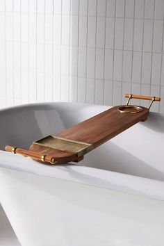 a bath tub with a wooden tray on it