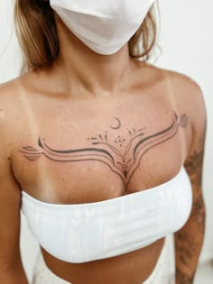 a woman wearing a face mask with tattoos on her chest