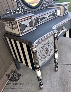 an antique vanity with black and white stripes on the bottom, painted in metallic paint