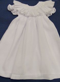 Hand smocked white dress with ruffle collar and delicate flowers. Size 2T is available $70.00 Prices varies according to size. For other sizes allow 3 to 4 weeks for delivery. This dress is an Easter dress, portraits or flower girl or any other special occasion. For custom orders allow 4 weeks for delivery. Formal Dress With Ruffled Collar And Details, Elegant Fitted Smocked Dress With Lace Trim, Baptism Dress With Flutter Sleeves And Ruffles, White Baptism Dress For Spring Garden Party, White Flutter Sleeve Dress With Smocked Bodice, White Dresses With Ruffled Collar For Spring, White Dress With Smocked Bodice And Flutter Sleeves, Fitted Dress With Smocked Back And Ruffled Collar, White Dress With Ruffled Collar For Spring