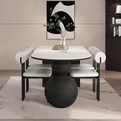 a white table with chairs around it and a black vase on the table next to it