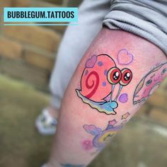 a woman's leg with tattoos on her legs and an image of a snail