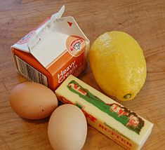 eggs, cheese, and other ingredients on a wooden counter top next to an orange