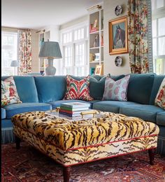 a living room with blue couches and colorful pillows on top of the rugs