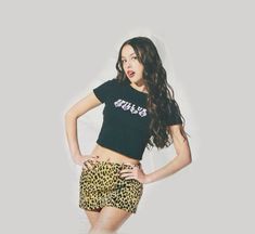 a woman in leopard print shorts and a black shirt with the word girls on it