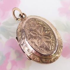 Ornately engraved floral motif designs decorate both sides of this antique 10k solid yellow gold locket pendant. The fully engraved floral reversible pendant features detailed linework, scrolling and floral details, which differs on each side. The locket opens with the help of two tiny knobs and closes securely with a light snap. Inside you will find both original frames attached to glass inserts. The locket tested as 10k gold in three locations (no hallmark). The large added bail at top is gold filled. This antique lovingly aged piece is in very good condition for its turn-of-the-century age. It has some expected surface wear and a few tiny dings to its outer shell. There are two dark lines where the trim was joined on each panel. Please see photos for condition and detailed measurements Oval Window, Gold Locket, Gold Engraving, Motif Design, Locket Necklace, Solid Yellow, 10k Gold, Floral Motif, Locket