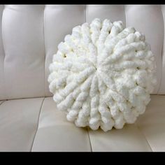 a white pillow sitting on top of a white couch