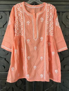 an orange top with white flowers on it