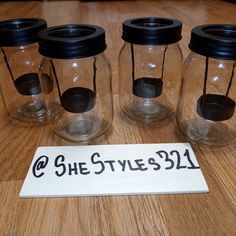 five glass jars with black lids are sitting on a wooden table next to a sign that says she styles 31