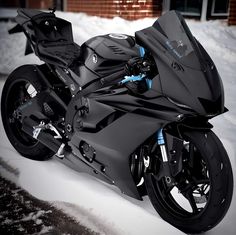 a black motorcycle is parked in the snow