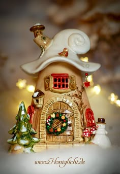 a ceramic figurine of a house with christmas decorations