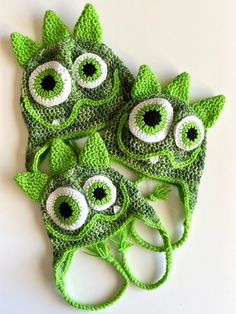 three green crocheted hats with eyes and leaves on them, one is for children