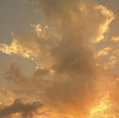 an airplane flying in the sky at sunset with clouds and sunbeams behind it