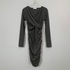 This dress features a V-neckline, pleating to create a shaping effect, and concealment of the tummy. The skirting is designed to fit closely to the body, adding a touch of elegance and sophistication to the overall look. The dress is a perfect choice for any occasion, whether it's a formal event or a night out on the town. The pleating also adds a touch of flexibility to the dress, allowing it to fit comfortably and move easilySeason: Spring, Summer, AutumnSize: FColor: Dark Grey, Black, Burgund Chic Stretch Mini Dress With Surplice Neckline, Elegant V-neck Midi Dress With Folds, Fall V-neck Ruched Midi Dress, Solid Stretch Dress With Surplice Neckline, Stretch Dresses With Surplice Neckline In Solid Color, Stretch Mini Dress With V-neck, Solid Color Stretch Midi V-neck Dress, Gray Stretch V-neck Dress, Fitted V-neck Dress With Folds