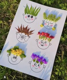 some flowers and plants are in the shape of faces on a sheet of white paper