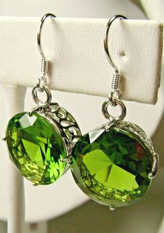 Simulated Green Peridot Earrings Round Design#E33 Made to Order This is a brand new beautiful Art Nouveau inspired filigree sterling silver pair of earrings. The gorgeous 20ctw captivating gems are high quality flawless man-made gemstones. The lovely round full cut simulated green peridots are 15mm (9/16") in diameter. The earrings are 1-5/16" long. Notice the beautiful intricate filigree designed of the settings. These are simple, elegant earrings with lovely detail.   Suggested Retail $179 **M Classic Green Peridot Earrings, Nickel-free Peridot Elegant Jewelry, Elegant Peridot Nickel-free Jewelry, Elegant Nickel-free Peridot Jewelry, Classic Green Drop Earrings, Green Faceted Round Earrings, Green Round Faceted Earrings, Classic Green Earrings For Party, Formal Green Nickel-free Earrings