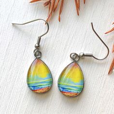 These gorgeous earrings feature a print of one of my original paintings glazed under glass, they measure approximately 0.50 x 0.70 inches and both the earwire and the bezel are stainless steel. Artistic Yellow Teardrop Jewelry, Artistic Yellow Teardrop Earrings, Artistic Teardrop Earrings With Artistic Design, Artistic Teardrop Earrings, Artsy Teardrop Earrings With Ear Wire, Nickel-free Teardrop Artsy Earrings, Artistic Teardrop Earrings With Ear Wire, Paper Earrings, Earrings Inspiration