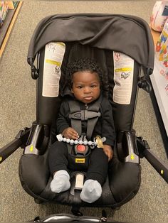 a baby doll sitting in a stroller on the floor