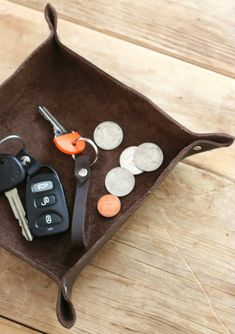 a car key and some coins in a tray