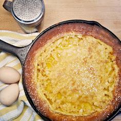 an uncooked pie sitting on top of a table next to eggs and a measuring cup