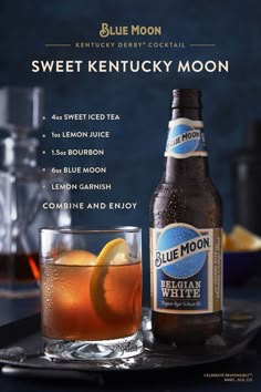 a bottle of blue moon next to a glass filled with ice and orange slices on a tray