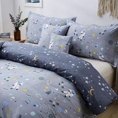 the comforter is made up with space themed sheets and pillowcases on it