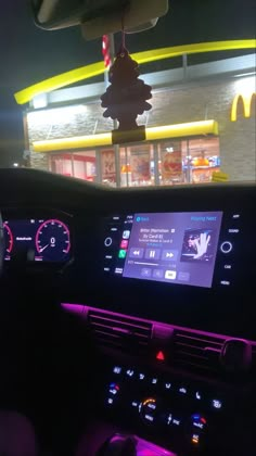 the dashboard of a car with a mcdonald's restaurant in the background at night