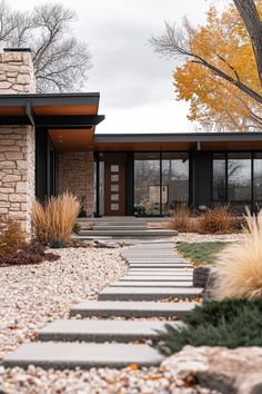 a modern house with stone walkway leading to the front door