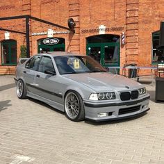 a silver car parked in front of a brick building