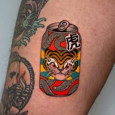 a man with a tattoo on his arm has a can of beer in the shape of a tiger