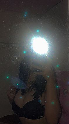 a woman taking a selfie in front of a mirror with green lights on it