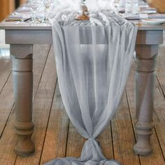 the table is covered with blue cloths and place settings for an elegant dinner party